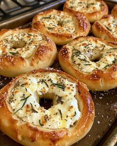 baked bagels with cheese and herbs on a baking sheet