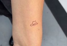 a small hat tattoo on the ankle