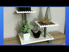 two tiered trays with plants and vases on each shelf, one holding a wine bottle