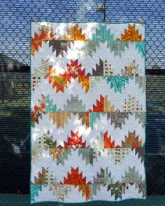 a quilt hanging on a chain link fence