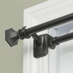 an image of a black curtain rod on the outside of a door that is closed