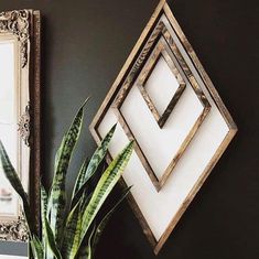 a potted plant sitting on top of a wooden table next to a framed mirror