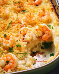 a casserole dish with shrimp and cheese on top, garnished with parsley