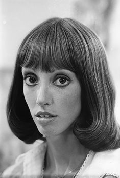 a black and white photo of a woman with bangs