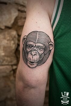 a man's arm with a tattoo of a monkey on the back of his head