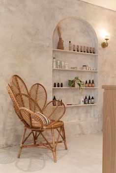 a bamboo chair sitting in front of a shelf filled with bottles