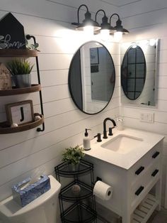 a bathroom with two sinks and three mirrors on the wall, along with toilet paper