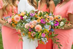 three bridesmaids in pink dresses holding bouquets of colorful flowers and greenery