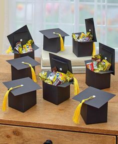 graduation cap boxes with candy in them on a table