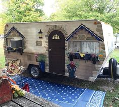 an old camper is decorated with flowers and potted plants