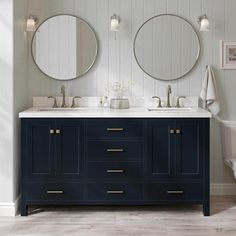 a bathroom with two sinks and mirrors on the wall