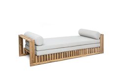 a white couch sitting on top of a wooden frame next to a pillow in front of it