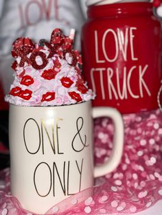 two coffee mugs decorated with red and pink decorations