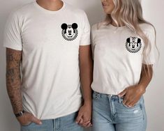 a man and woman standing next to each other wearing mickey mouse t - shirt designs