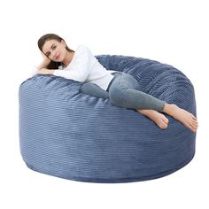 a woman laying on top of a blue bean bag chair