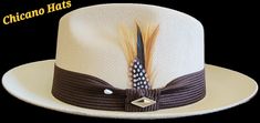 Goldline fine finish Khaki Viejo made with the finest cotton string, 2 1/2 brim, Brown band,real feather,pearl pin. Choice of flip up or down brim White Adjustable Hat Band With Feathers, Adjustable White Hat Band With Feathers, Adjustable White Hat Bands With Feathers, Feathered Brimmed Hat Bands For Summer, Brimmed Hat Bands With Feathers For Summer, Adjustable Beige Hat With Feathers, Feathered Hat Bands For Beach Events In Summer, Adjustable Feather Hat Bands For Summer, Pearl Pin