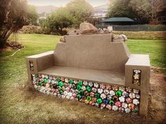 a bench made out of bottles in the grass