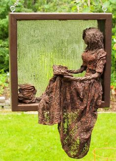 a woman sitting on a swing in the grass