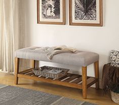 a bench sitting in front of two pictures on the wall next to a basket with books