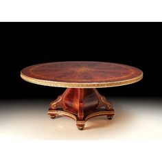 a table with an oval wooden top and gold trimmings