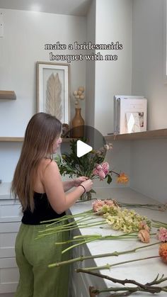 a woman arranging flowers on a counter top