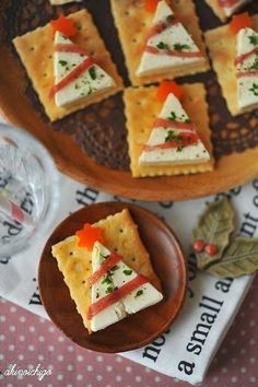 there are crackers with cheese and veggies on them