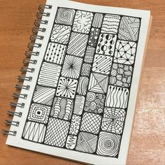 a notebook with doodles on it sitting on top of a wooden table