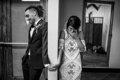 a man and woman standing next to each other in front of a doorway with their hands on their face