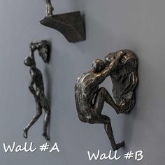 three metal figurines hang on the wall next to each other in different positions