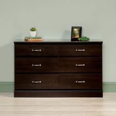 a brown dresser sitting on top of a hard wood floor