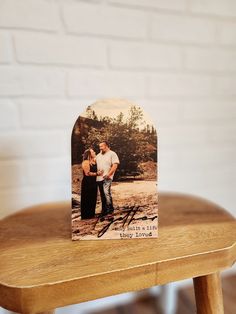 a wooden table with a card on it that has an image of two people standing next to each other