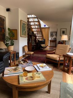 a living room filled with furniture next to a stair case