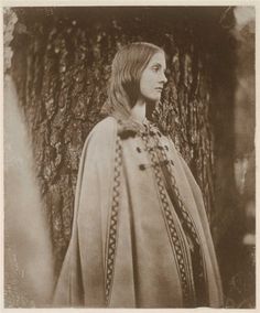 an old black and white photo of a woman wearing a cape