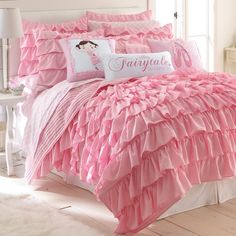 the comforter is pink and white with ruffles on it