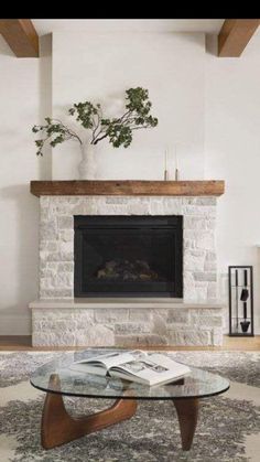 a living room with a fire place and a glass table in front of the fireplace