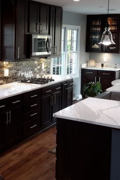 a kitchen with black cabinets and white counter tops