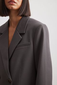 This blazer features a classic collar. It has long sleeves with padded shoulders and button closures at the cuffs and a breast pocket on the side. This blazer features front flap pockets, seam details on the front and on the back, four button closures on the front, an inside pocket with a button closure, a lining and an oversized fit. Classic Button-up Blazer For Work, Tailored Long Sleeve Blazer Dress With Hidden Buttons, Formal Long Sleeve Blazer Dress With Single Button, Solid Blazer With Pockets For Office Wear, Notched Solid Color Formal Blazer, Office Wear Lapel Collar Blazer, Solid Notched Blazer For Formal Occasions, Office Wear Blazer With Lapel Collar, Solid Single Breasted Semi-formal Blazer