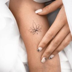 a woman's arm with a small flower tattoo on the left side of her body