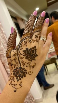 a woman's hand with henna tattoos on it