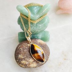 "You can choose your own gem in my store. Let me know if you would like to see options Gemstone: Brown YellowTiger Eye Gold Purity : Guaranteed 14kt pure GOLD Gem weight 9.60 carats Gem shape: Marquis Cabachon shape Gold weight: 0.56 grame Total weight: 2.48 grame The Gemstone in this pendant is ethically sourced and is exploitation free. Brown Yellow Tiger Eye is a beautiful Gemstone of patterns like no other Gemstone. Please note that the pendant is made with absolutely pure 14kt Gold. Pendant Number Jewelry, Gold Tiger, Brown Tiger, Gold Tiger Eye, Brown Tiger Eye, Tiger Eye Jewelry, Heavy Chain, Bezel Pendant, Solid Gold Rings