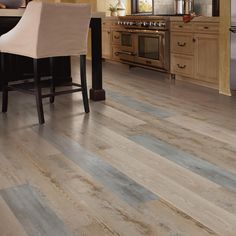 a kitchen with wood flooring and stainless steel appliances in the back drop off area