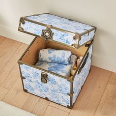 a blue and white suitcase sitting on top of a wooden floor