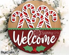 a wooden sign that says welcome with candy canes