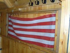 an american flag hanging on the side of a wooden wall in a room with wood paneling