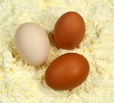 three eggs sitting on top of white flour