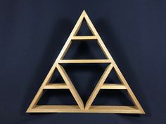 a wooden shelf with three triangulars on it against a black background, in the shape of a triangle