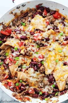 skillet burritos with cheese, black beans and peppers in a white casserole dish