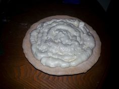 a doughnut with white icing sitting on top of a wooden table