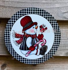 a plate with a snowman holding a candy cane