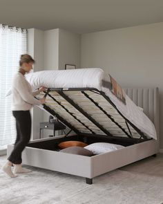 a woman unpacking a bed with a mattress on it